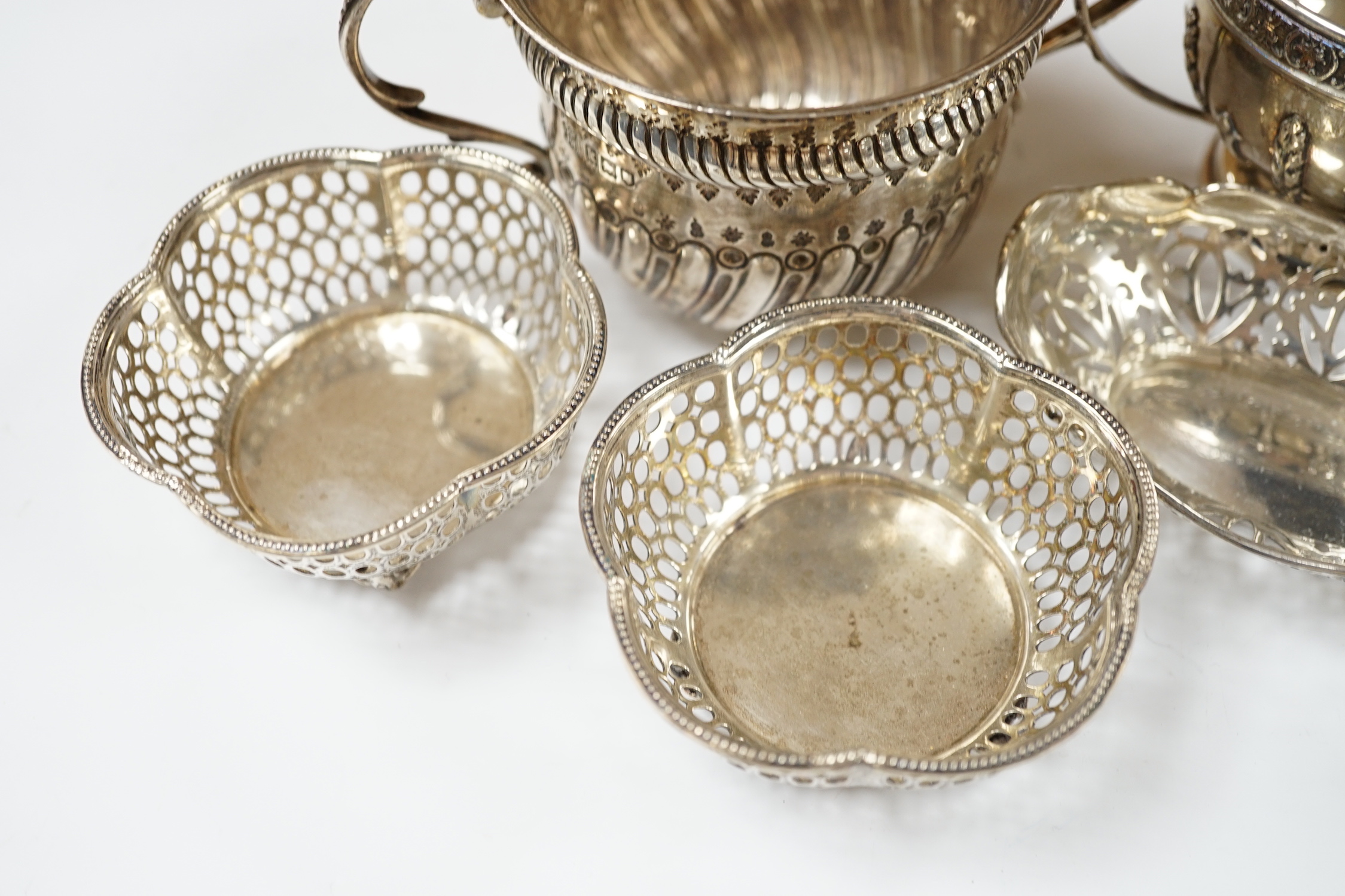 An Edwardian repousse silver porringer, Daniel & John Welby, London, 1905, diameter 92mm, a pair of pierced silver bonbon dishes, one other similar bonbon dish, a silver two handled bowl and a modern silver taste vin